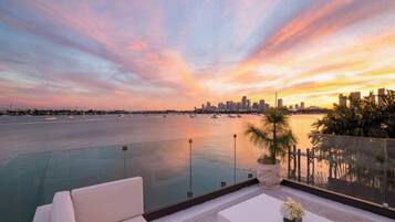 A rooftop pool with a city skyline view at sunset.