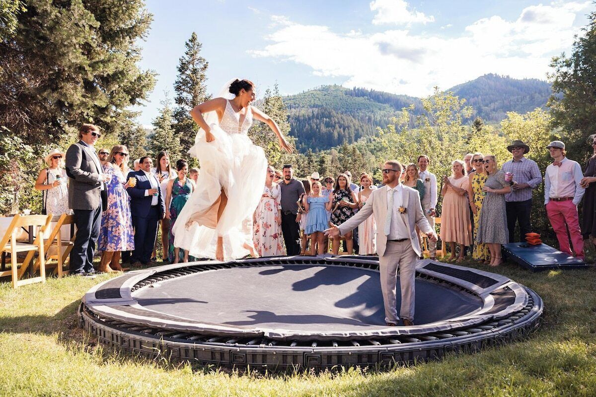 A wedding ceremony with guests standing around a trampoline.