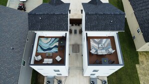 A two-story building with a rooftop patio area featuring outdoor furniture and a large rug. - Whole Home 1012 & 1014 Franklin (Clarksville)