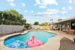 Ein Swimmingpool mit einem rosa Flamingo-Schwimmpfiff und einem Schwimmpfiff mit blauem Blattmuster.