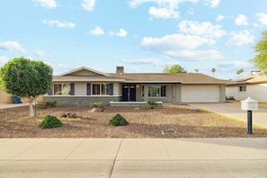 A residential house with a front yard, a garage, and a mailbox.