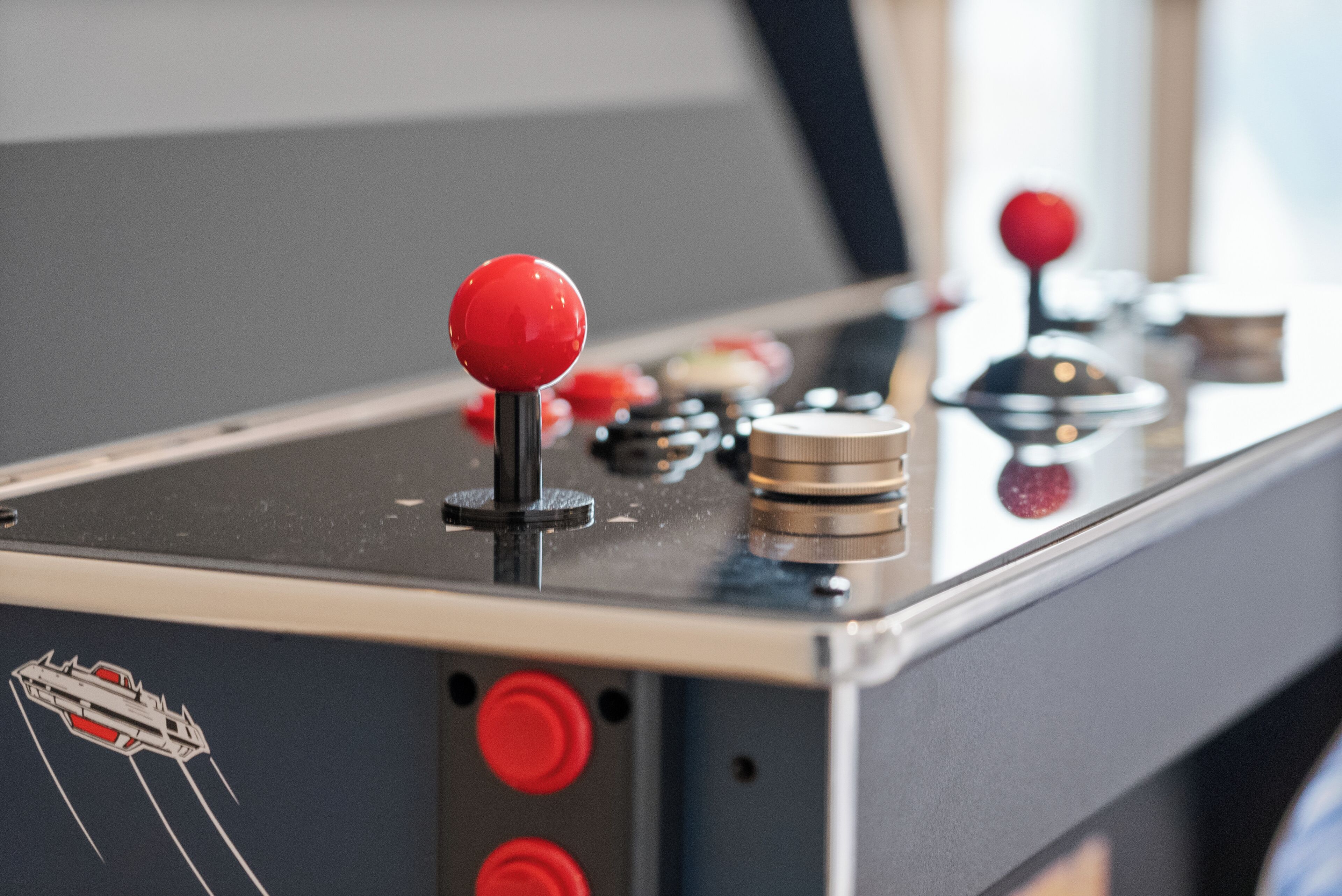 A close-up of a game control panel with red buttons and joystick.