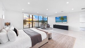 Una camera moderna con un letto grande, una TV, una scrivania e vista sull'esterno.