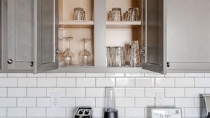 A kitchen with a built-in cabinet containing glassware and jars. - Spacious Whitestown Getaway (Whitestown)