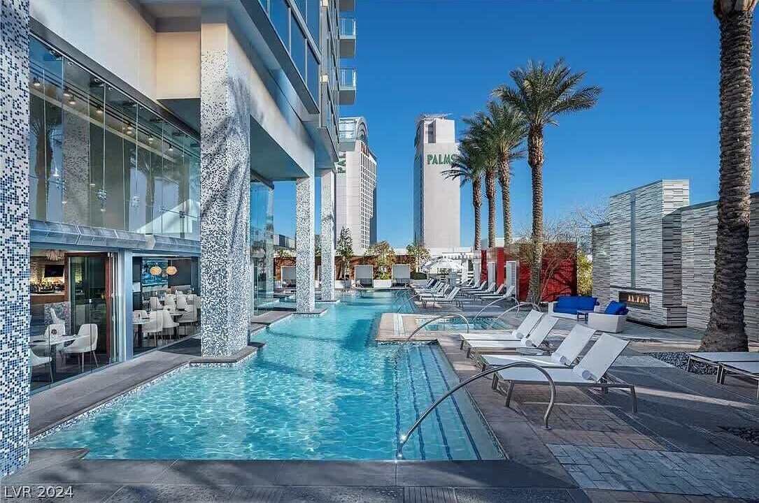 Un hôtel doté d’une piscine, de chaises longues et de palmiers.