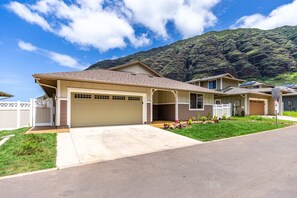 A residential house with a garage, a covered porch, and a well-maintained lawn. - @ Marbella Lane - Mesmerizing Ocean + MT Views (Waianae)
