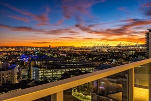 A cityscape at dusk with illuminated buildings and a clear sky.