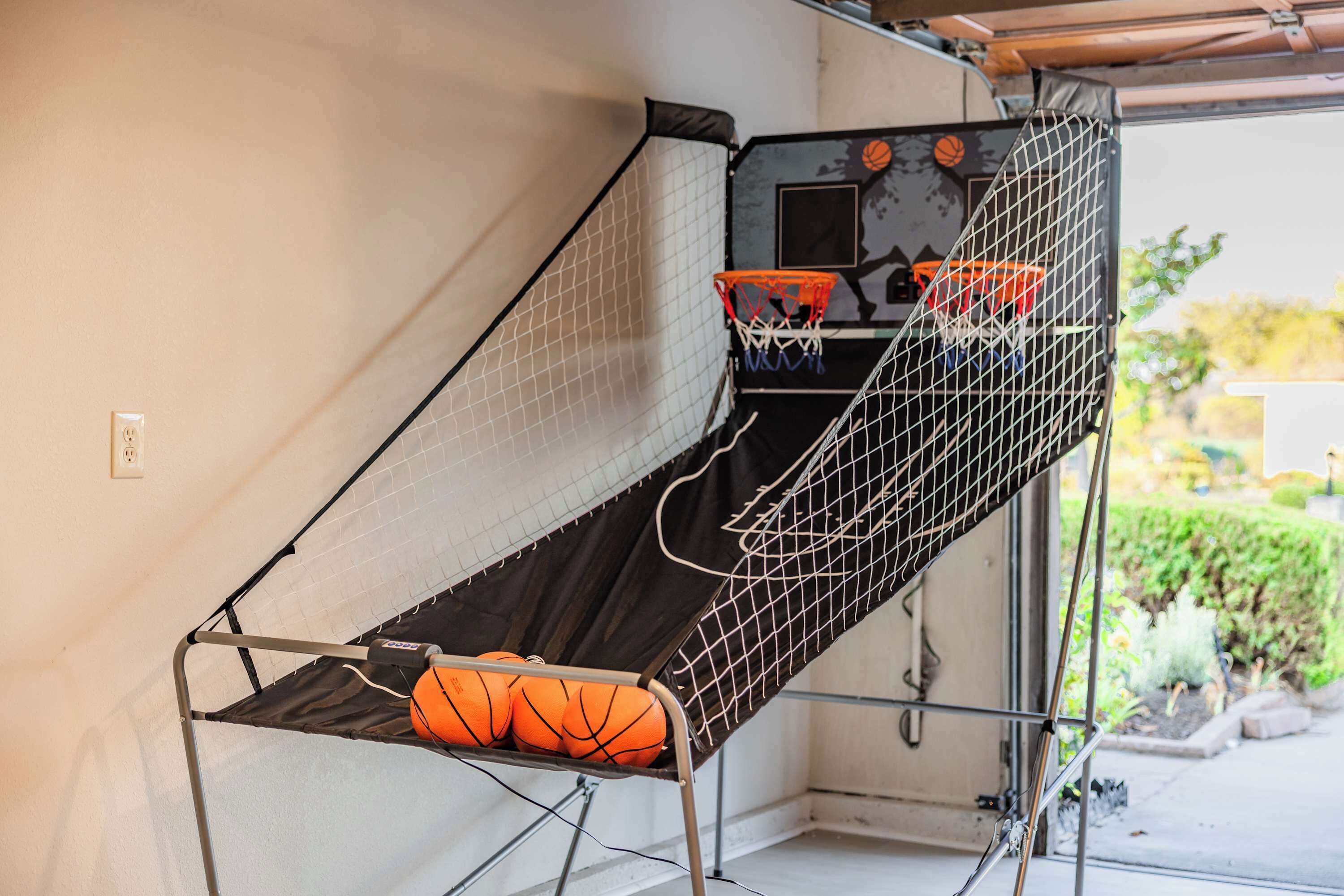 A basketball hoop with a net, mounted on a wall.