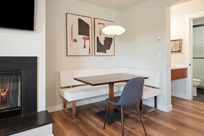 A modern living room with a fireplace, white sofa, dining table, and a grey chair. - Seventh Mountain 1417 or 1418 (Bend)
