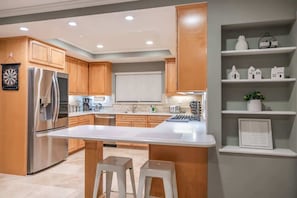 A modern kitchen with wooden cabinets, stainless steel appliances, and a central island. - Marbella Lane - Charming 4BR Bungalo for Relaxing Retreat (Fullerton)