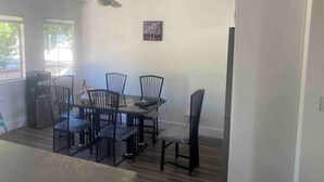 A dining area with a table and chairs, a ceiling fan, and a window with a view. - @ Marbella Lane - Majestic Desert Mountain Views (Desert Hot Springs)