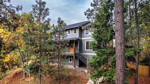 A modern two-story house surrounded by tall pine trees. - Evergreen Retreat A 30 Night Minimum (White Salmon)