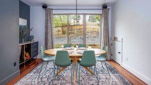 A dining area with a round table, green chairs, a patterned rug, and a view of the outdoors. - Evergreen Retreat A 30 Night Minimum (White Salmon)
