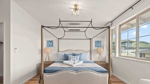 Ein Himmelsbett mit Baldachin, eine Nachttischlampe und Kunstwerke an den Wänden.
