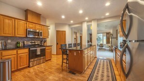 A modern kitchen with wooden cabinets, stainless steel appliances, and a central island. - Slope View (Parkdale)