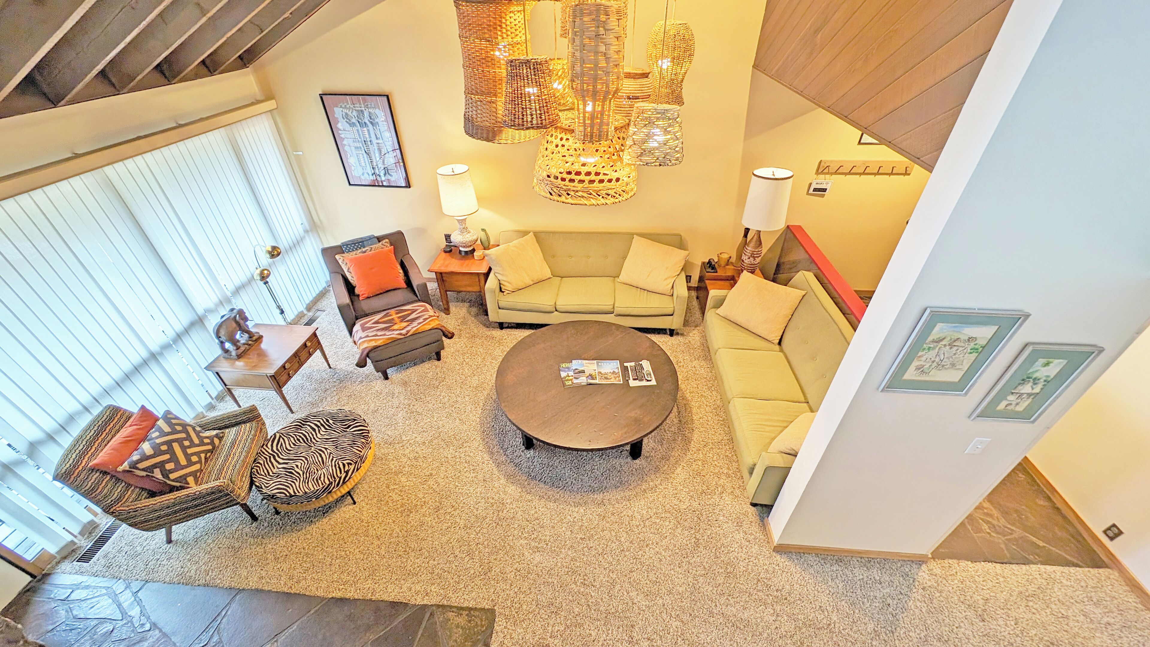 A spacious living room with a large round coffee table, two sofas, and a variety of decorative items including a chandelier and wall art.