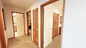 A hallway with wooden doors and a carpeted floor. - Meadow House 42 (Bend)