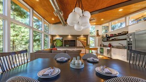 A modern kitchen with a dining area, large windows, and a wooden ceiling. - Happenstance Vineyards King Rooms (Mosier)