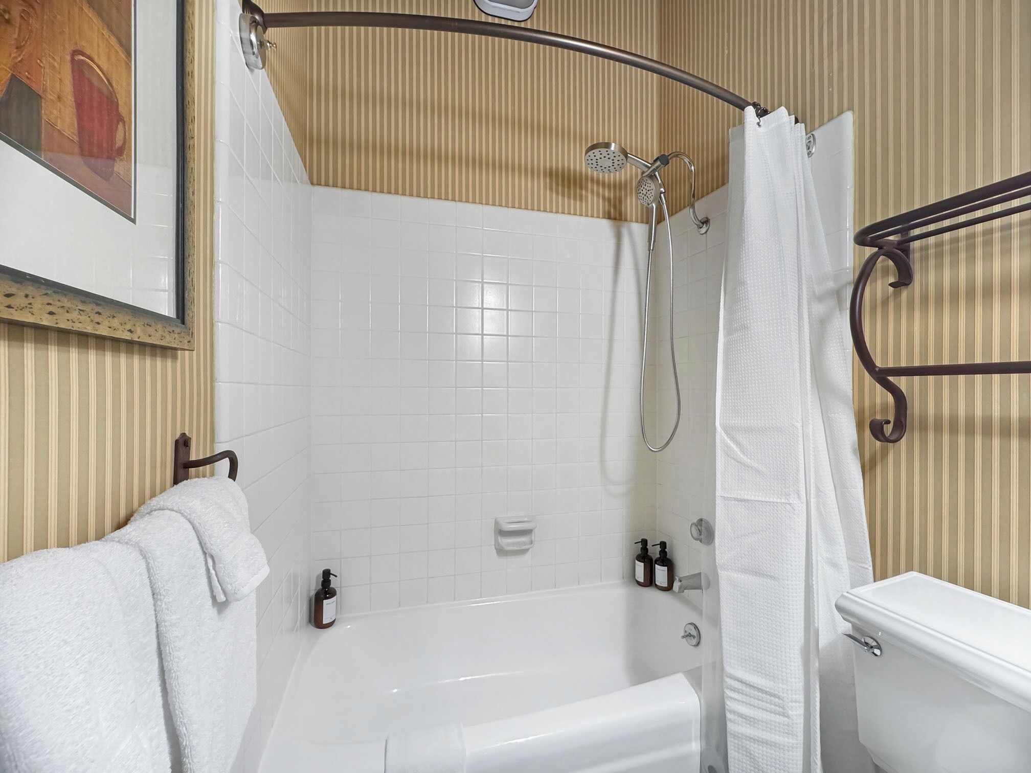 A bathroom with a bathtub, toilet, and shower.