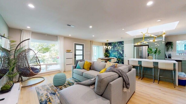 A modern living room with a sofa, a hanging chair, a dining area, and a kitchen. - Marbella Lane - SJ Designer Home 3BR Ldry P (San Jose)