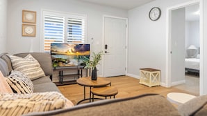 A living room with a sofa, TV, and a small table with a plant. - Marbella Lane - Serene Haven Retreat 3BR (Ontario)