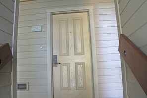 A wooden door with a number plate indicating the address 923.