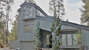 A modern two-story house with large windows and a garage. - Whistling Swan 8 (Bend)