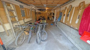 A narrow hallway with bicycles parked on the left and a red object on the right. - Whistling Swan 8 (Bend)