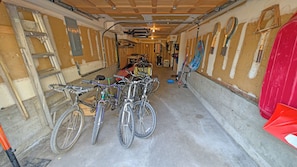 A narrow hallway with bicycles parked on the left and a red object on the right. - Whistling Swan 8 (Bend)