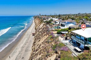 A coastal residential area with houses, a beach, and a view of the ocean. - Oceanfront Neptune Ave Home | Panoramic Views, Luxury Coastal Living, Walk To The Beach (Encinitas)