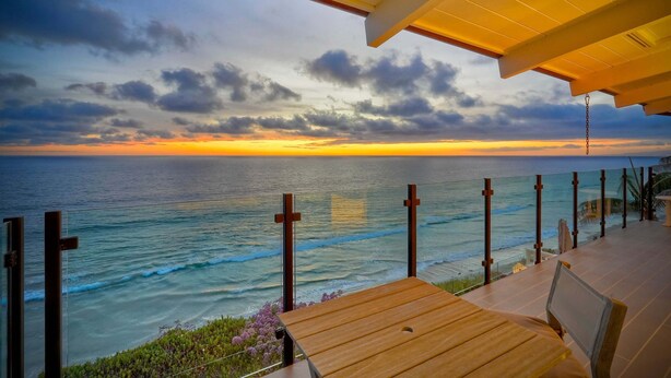 A wooden deck with a view of the ocean at sunset. - Oceanfront Neptune Ave Home | Panoramic Views, Luxury Coastal Living, Walk To The Beach (Encinitas)