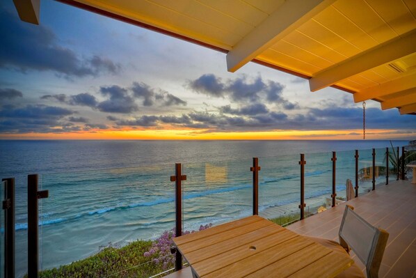 A wooden deck with a view of the ocean at sunset. - Oceanfront Neptune Ave Home | Panoramic Views, Luxury Coastal Living, Walk To The Beach (Encinitas)