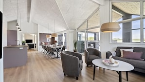 A spacious living area with a dining table, sofas, and a kitchen area with a modern design. - VillaVilla 958 - Skåstrup Strand, Fyn og øer (Bogense)