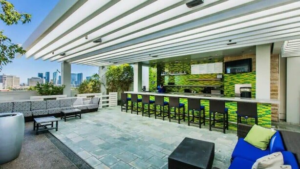 Een terras met een bar, banken en stoelen.