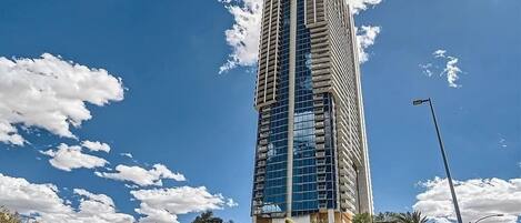 A tall, modern skyscraper with a glass facade and a unique architectural design.
