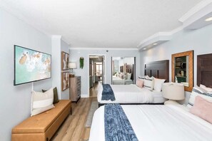 Ein modernes Hotelzimmer mit einem großen Bett, einer Couch, einem Fernseher und einem Schreibtisch.