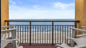 A balcony with a view of the ocean, white wicker chairs, and a metal railing. - Caravelle 1445 (Myrtle Beach)