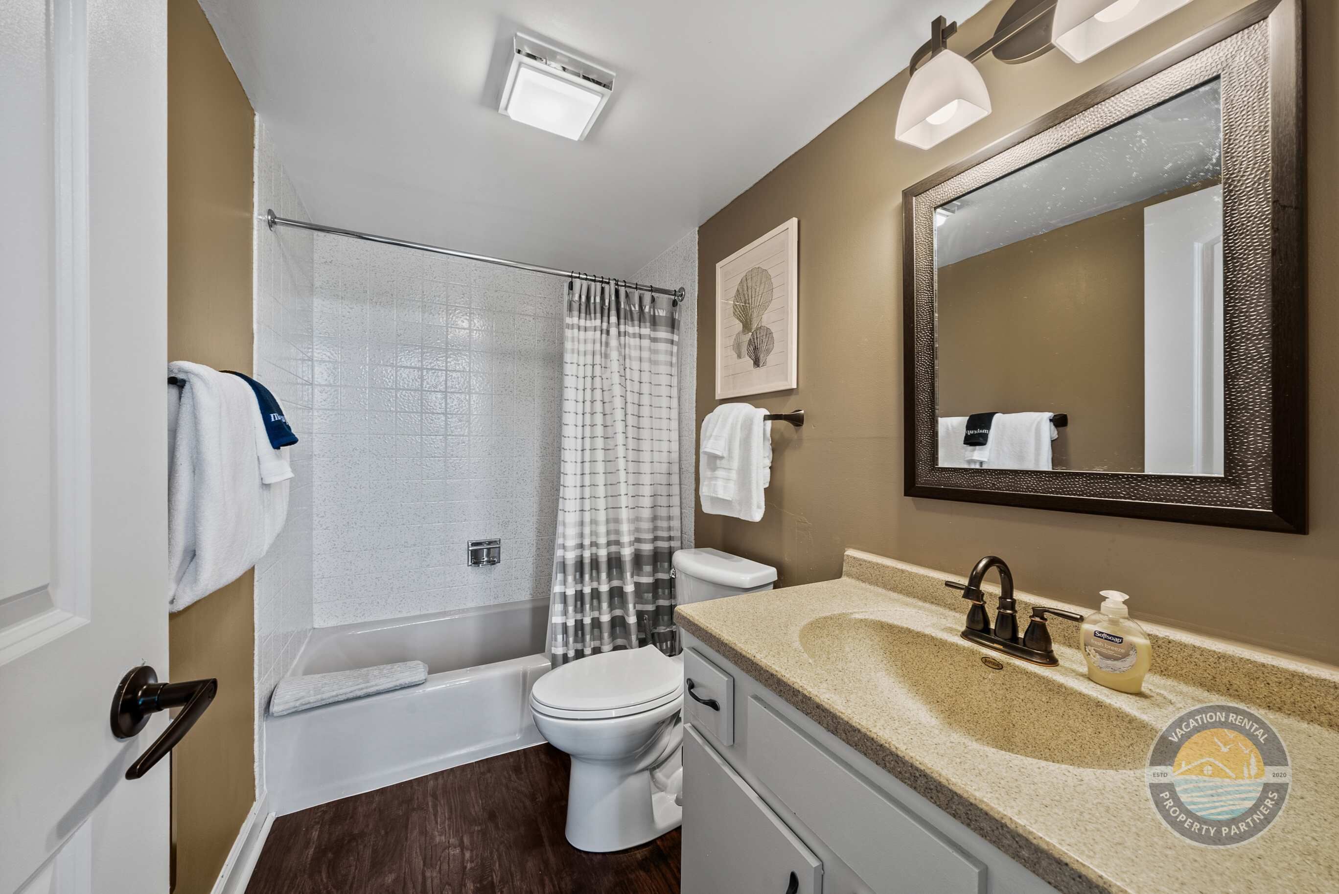 Une salle de bain avec une baignoire, des toilettes, un lavabo et un grand miroir.