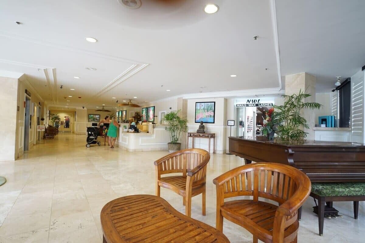 Um hall amplo com cadeiras de madeira e um balcão de recepção.