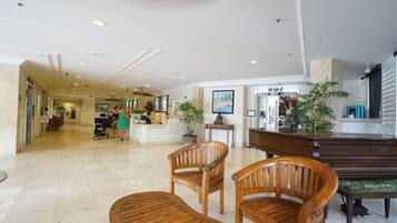 Um hall amplo com cadeiras de madeira e um balcão de recepção.