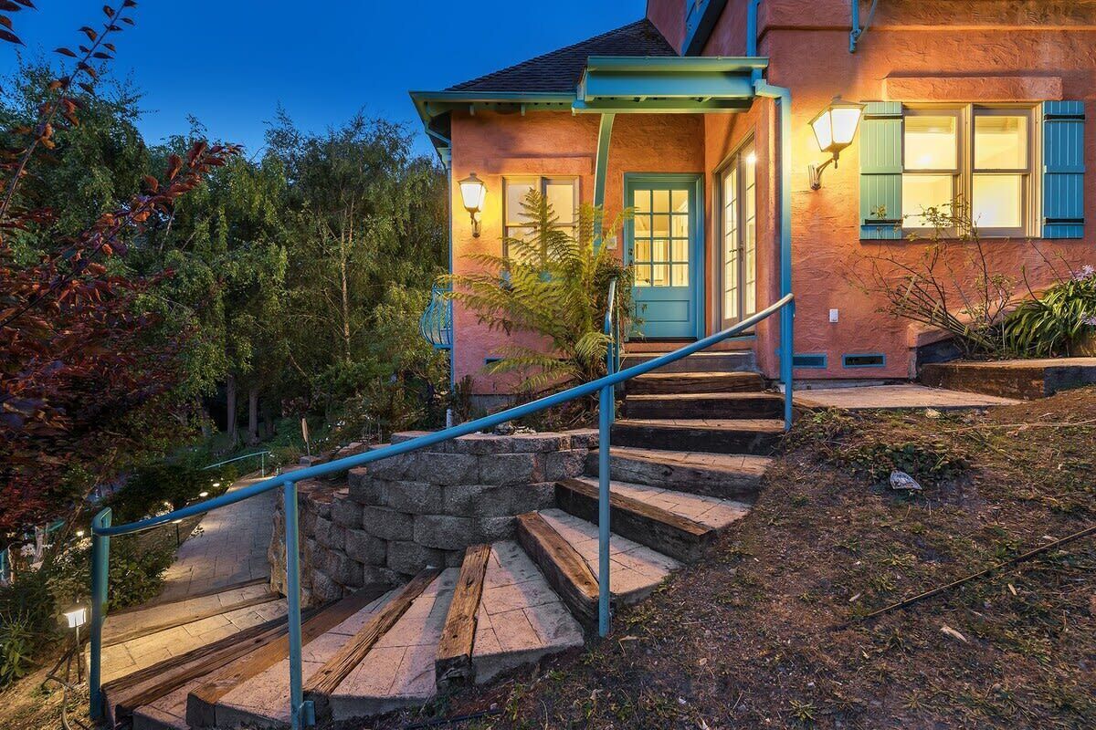 Una casa con una scala in pietra che conduce a una porta con persiane blu.