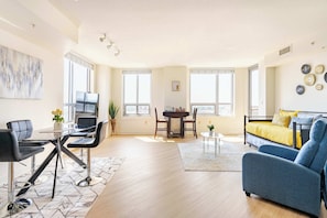 Una sala de estar moderna con comedor, una cama y ventanas amplias.