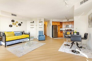 A modern living room with a sofa, a coffee table, and a dining area with chairs.