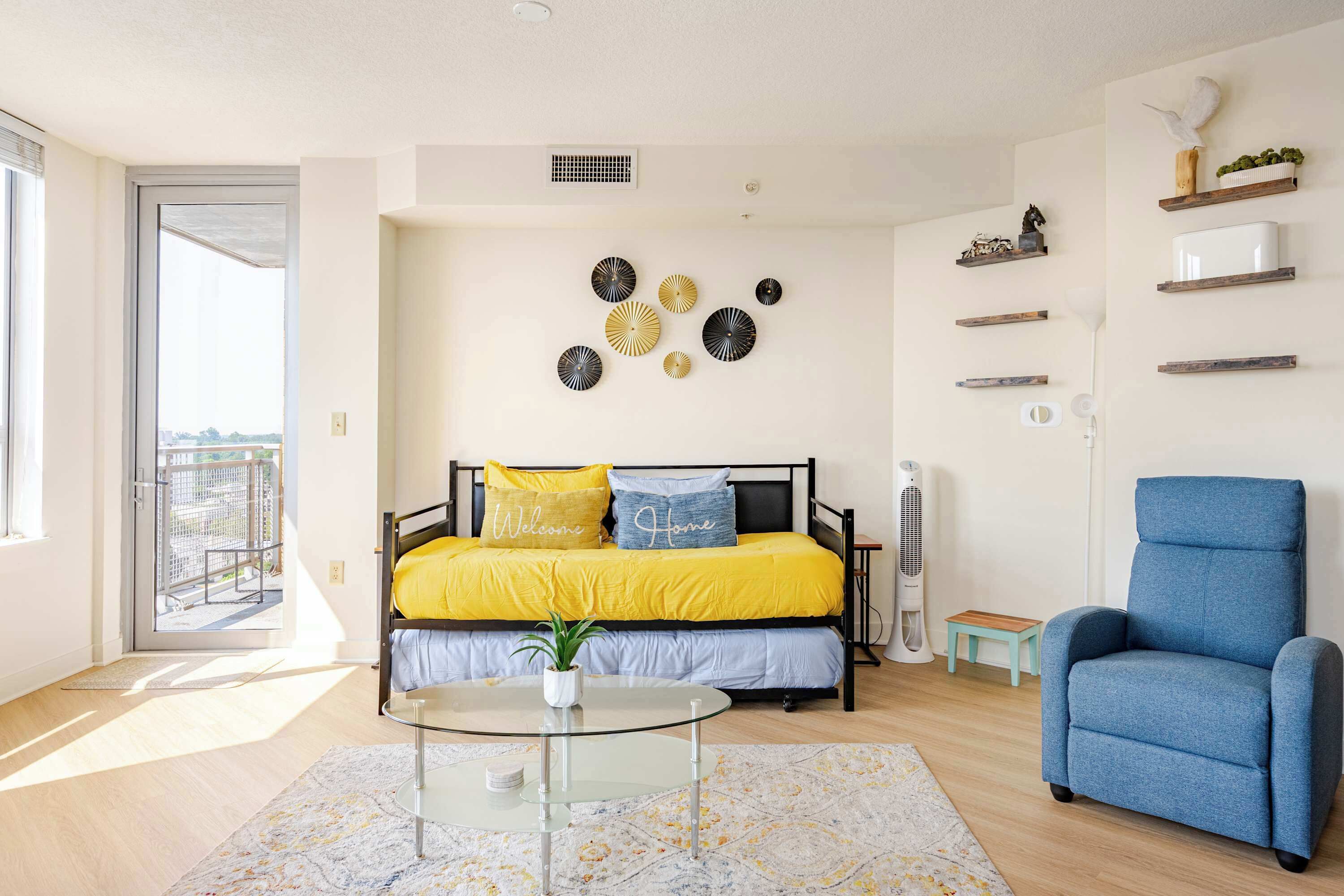 Una camera da letto con un letto, una sedia, un tavolino e decorazioni a parete.
