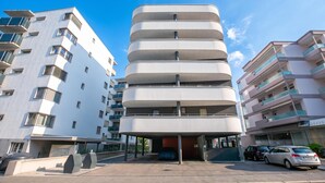 En modern, flervåningsbyggnad med en unik, cylindrisk design, omgiven av andra bostadshus.