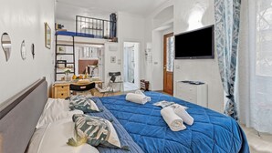 A bedroom with a bunk bed, a desk with a chair, a TV, and a window with curtains. - Festival Riviera House Sanremo Old Town Sleeps 4, Sanremo, Italy (Sanremo)