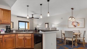 A kitchen with wooden cabinets, a dishwasher, a coffee maker, and pendant lights. - Spend the 4th of July at the beautiful Bonnet Creek Reaort in Orlando Florida (Lake Buena Vista)