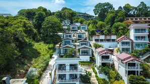 Un quartier résidentiel situé sur une colline, composé de nombreuses maisons à deux étages, chacune dotée de balcons et de grandes fenêtres.