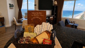 A room with a view of the ocean, a welcome sign, a dining area, and a TV. - Golden Hour Penthouse  -  Beach Front,  2 BR/2 Bath Penthouse (Panama City Beach)