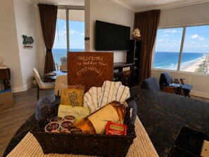 Ein Zimmer mit Meerblick, ein Willkommensschild, eine Essecke und ein Fernseher.